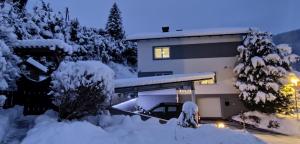 巴德小基希海姆Residence Alba Montis的前面有一堆积雪的房子