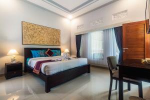 BangliAsli Bali Villas的一间卧室配有一张床、一张书桌和一张书桌