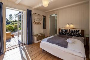 欧德尔Norsminde Kro Anneks的一间卧室设有一张大床和一个滑动玻璃门