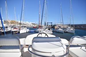 圣米格尔德阿沃纳Luxury Yacht Kamikara的码头上一艘带椅子和船只的船