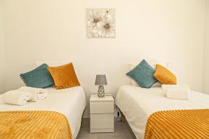 阿尔曼萨O PINHAL DO AVÔ的一间卧室配有两张床和床头灯。