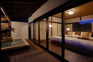伊豆Sakahijiri gyokushoen的一间卧室设有两张床和玻璃墙