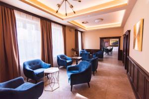 特普利采Wellness Hotel Pivovar Monopol的一间设有蓝色椅子和桌子的等候室