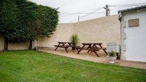 托雷拉韦加La casa de Virginia的后院设有两张野餐桌和一张长凳