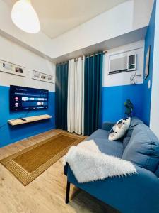 马尼拉Cozy Place Anuva Residences的客厅配有蓝色的沙发和电视