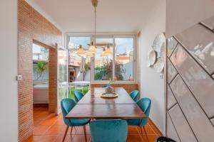 塞图巴尔Setúbal Oasis House的一间带木桌和蓝色椅子的用餐室