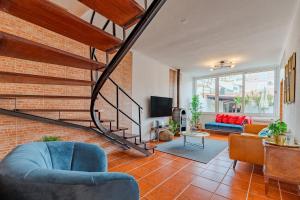 塞图巴尔Setúbal Oasis House的一间带楼梯和砖墙的客厅