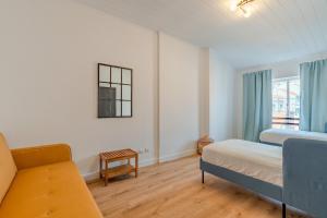塞图巴尔Setúbal Oasis House的一间卧室配有一张床、一张沙发和一个窗口