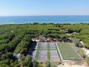 丽都迪丰迪Le Dune Villaggio的享有网球场和海洋的空中景致