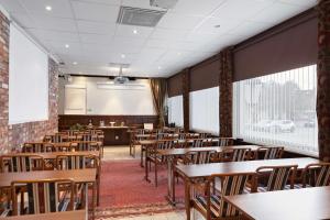 韦特兰达韦特兰达斯坦茨贝斯特韦斯特酒店的一间空的教室,配有木桌和椅子