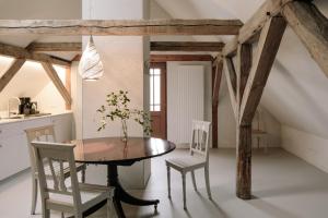 萨勒Apartment Alte Schmiede的厨房以及带木桌和椅子的用餐室。