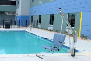 柏斯海滩Microtel Inn & Suites by Wyndham Rehoboth Beach的大楼前带椅子的游泳池