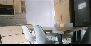 开普敦Blue Nile Guest的一间会议室,配有木桌和白色椅子