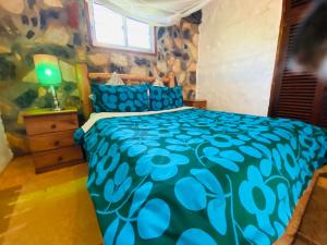 金贾HomeOnTheNile的一间卧室配有一张带蓝色棉被的床