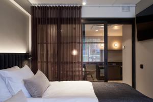 卡亚尼Original Sokos Hotel Valjus Kajaani的卧室配有白色的床和滑动玻璃门