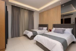 开罗Kattameya dunes 4 master bedrooms villa的酒店客房,设有两张床和窗帘