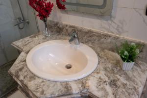 开罗Kattameya dunes 4 master bedrooms villa的浴室里装有红色花卉的白色水槽