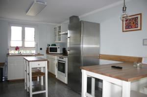 米特韦达Quartier78的厨房配有不锈钢冰箱和桌子