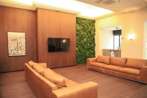 贝洛奥里藏特金融酒店的一间设有两张沙发和一台平面电视的等候室
