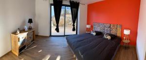 Arras-en-LavedanLe hautacam的一间卧室设有一张床和橙色的墙壁
