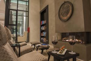 哈马马特巴迪拉成人酒店的客厅设有壁炉和2杯葡萄酒