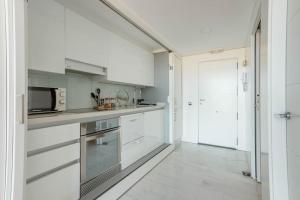 瓦伦西亚Duplex LOFT Apartamento con Parking GRATIS的厨房配有白色橱柜和微波炉
