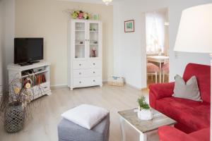 瓦尔肯里德阿姆库普弗贝格公寓的客厅配有红色沙发和电视