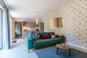 岑平Haus Silvana的一间带绿色沙发的客厅和一间厨房