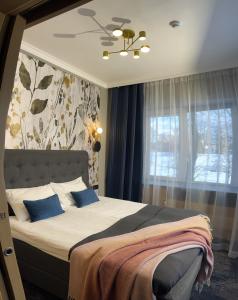 派尔努Sadama street Villa的一间卧室配有一张带蓝色枕头的床和一扇窗户。