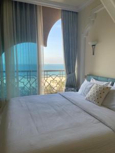 拉斯阿尔卡麦Private Suites Al Hamra Palace at golf & sea resort的一间卧室设有一张大床,享有海景