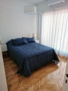 布宜诺斯艾利斯Hermoso Departamento en Recoleta muy luminoso的一间卧室设有蓝色的床,铺有木地板。