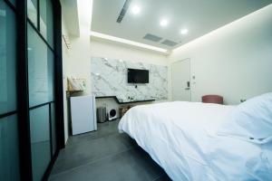 虎尾镇會呼吸的房507-睡虎尾-電梯bnb的卧室配有白色的床和电视