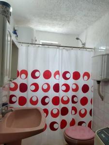 拉帕洛马Mar的浴室设有红色和白色的浴帘和卫生间
