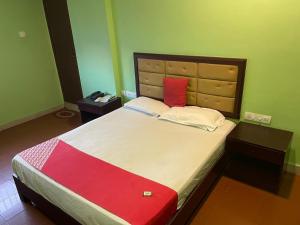 科泽科德Select Residency的一间卧室配有一张带红色枕头的大床