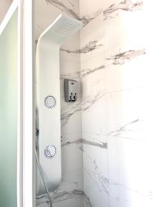 马贝拉Hostal El Caprichito Marbella的带淋浴的浴室(以白色大理石装饰)