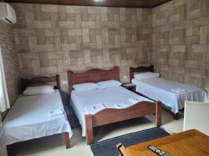 坎布里Pousada Mar & Sol de Camburi的一间设有两张床铺的客房,位于一个墙上