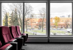 圣彼得堡斯普妮可酒店的窗户前的带红色椅子的等候室