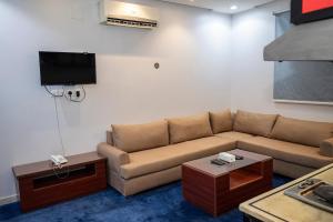 利雅德Ahlin Suites 5的带沙发和电视的客厅