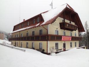 默尼希基兴Frühstückspension Koderholt的雪地中带雪盖屋顶的建筑