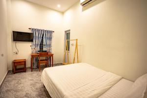 顺化Mini hotel Lạc Hồng的白色卧室配有床和书桌