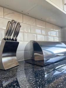 弗特威克Flitwick Luxury Apartment的两把刀子坐在厨房台上