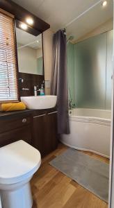 道利什Blue Water Breaks - Dawlish Warren的浴室配有盥洗盆、卫生间和浴缸。