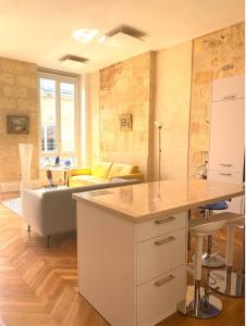 波尔多Fantastic 3-Room apartment heart of les Chartrons - Bordeaux的厨房以及带桌子和沙发的客厅。