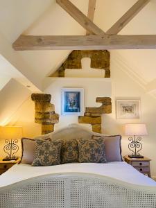 奇平卡姆登Campden Mews的卧室配有白色的床铺和石墙