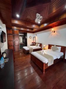 琅勃拉邦Chaluenxay Boutique hotel的大房间设有两张床和电视