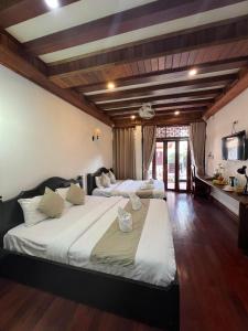 琅勃拉邦Chaluenxay Boutique hotel的一间带两张床的卧室和一间厨房