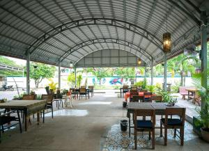 贡布Villa Kampot Cafe的一间带桌椅和大型屋顶的餐厅