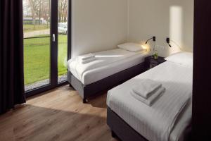 拉斯罗普Hofparken De Bergvennen的带大窗户的客房内的两张床