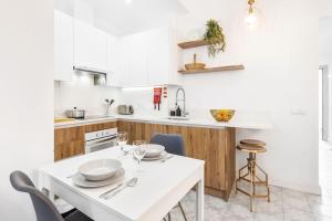 法鲁RG Casa do Carmo的白色的厨房配有白色的桌子和椅子