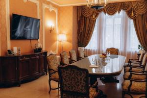敖德萨布里斯托尔酒店的一间带桌椅和电视的用餐室